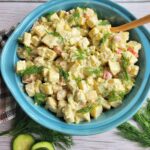 A serving bowl of classic sweet potato salad garnished wih fresh dill