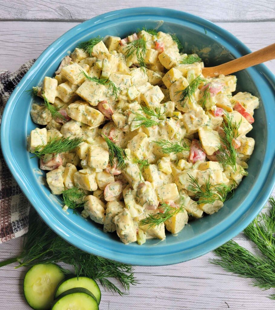 A serving bowl of the classic sweet potato salad garnished with fresh dill