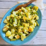 Platter of Garlic Roasted Cauliflower and Green Beans with an olive wood serving spoon